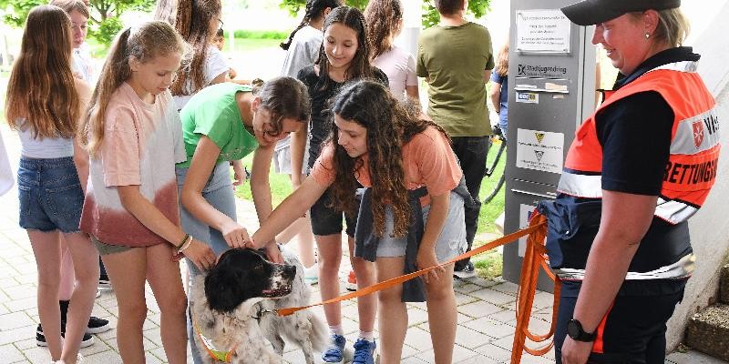 Schülerinnen und Schüler mit einem Rettungshund
