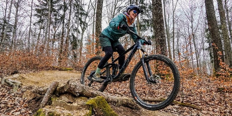 LE, sportlich gesehen Mountainbikerin fährt auf einem Trail durch den Wald