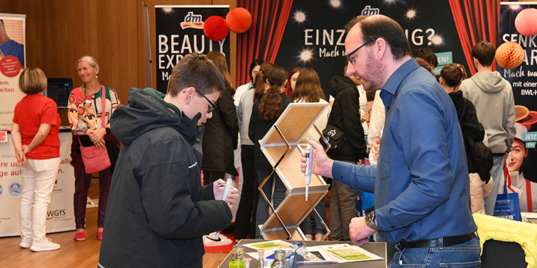 Besucher informiert sich an einem Firmenstand