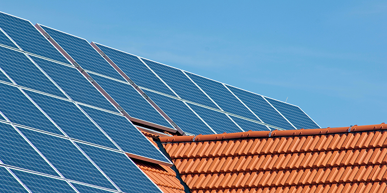 Themen-Special: PV-Bündelungsaktion Solaranlage auf einem Ziegeldach unter blauem Himmel
